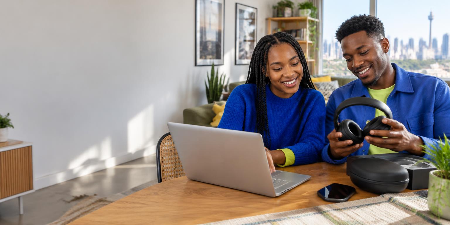 Illustrative South African couple comparing a laptop and headphones